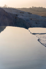 Calm pond in white limestone mountains in Pamukkale, Turkey on a sunny day