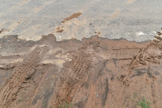tire track on diry soil and asphalt road for background