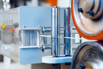 Inside a modern plant producing power electric cables and optical fibers. .Cable manufacturing machine part. Close up.