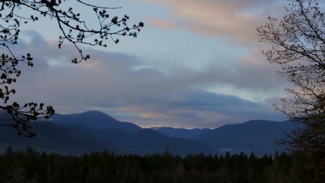 Incredible early morning sunrise time lapse over the mountains and trees with two directional cloud movement