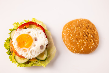 Burger with vegetables and egg on the white background isolated