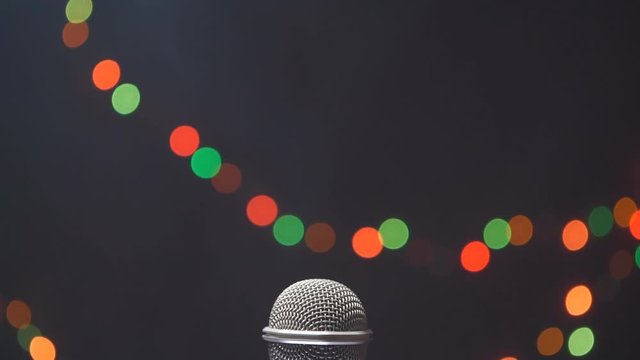 Microphone on stage in a smoke against the background of multi-colored lights
