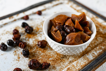 Sweet and soft dried Apple and rose hips prepared for dessert, decorated with a sprig of lavender and dry fruits on an unusual white and rusty metal background