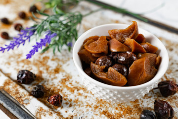 Sweet and soft dried Apple and rose hips prepared for dessert, decorated with a sprig of lavender and dry fruits on an unusual white and rusty metal background