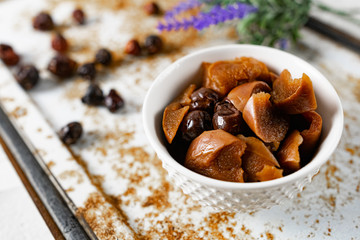 Sweet and soft dried Apple and rose hips prepared for dessert, decorated with a sprig of lavender and dry fruits on an unusual white and rusty metal background