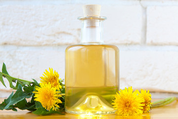 dandelion essential oil in  beautiful bottle on table © solstizia