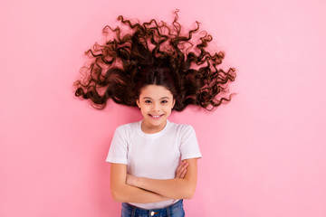 Top view above high angle flatlay lie concept portrait of her she nice attractive pretty funny cheerful cheery wavy-haired girl shine healthy curls folded arms isolated on pink pastel color background