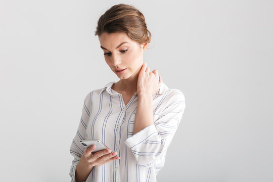 Image of serious beautiful woman typing on mobile phone
