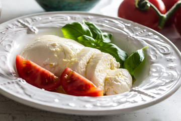 Mozzarella cheese tomatoes basil and olive oil. Caprese salad - italian or mediterranean meal or appetizer