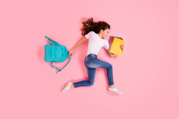 Top view above high angle flat lay flatlay lie concept portrait of nice beautiful cheerful small little wavy-haired girl carrying bag running lesson isolated over pink pastel color background