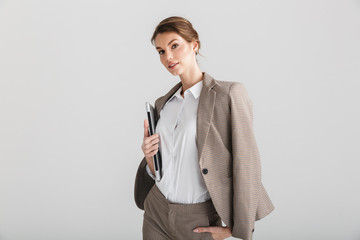 Image of serious pretty woman posing with laptop on camera