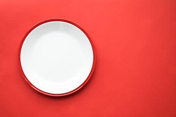 White and red plates on a red background, top view