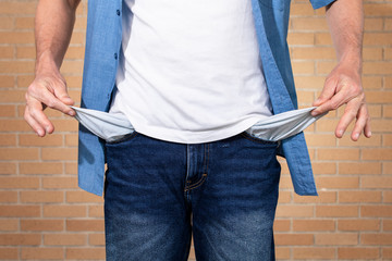 freelance man showing his empty pockets. Concept of bankruptcy.