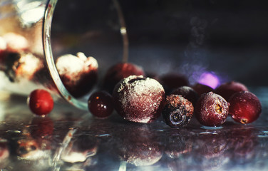 closeup frozen berries on the glass . frozen berries on a dark background macro. cranberries blueberries and cherries