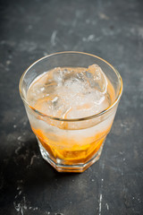 Old fashioned beverage with orange slices on rustic background. Selective focus. Shallow depth of field.
