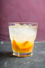 Old fashioned beverage with orange slices on rustic background. Selective focus. Shallow depth of field.