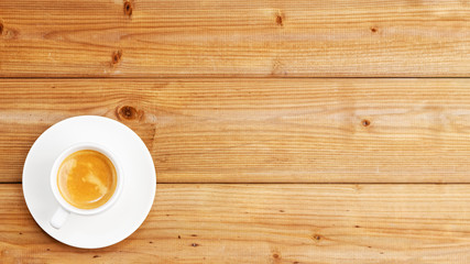 White cup of coffee espresso on wooden background. Top view with copyspace.
