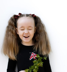a little girl laughs with her eyes closed against a white background