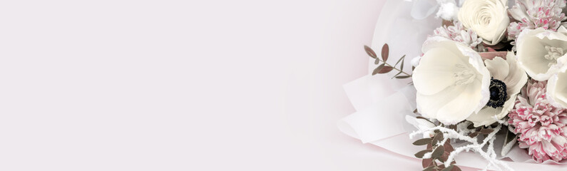 Close-up bouquet of flowers on a pink background, spring tulips of white color with hyacinth and buttercup. Banner with place for text and your advertisement.