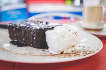Close up image of a chocolate brownie being served as a desert in a restaurant