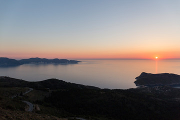 Fototapeta na wymiar sunset at sea seen from a viewpoint in Kefalonia, Greek island, the water is calm and the sky takes on orange tones