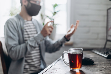 quarantine due coronavirus pandemic. stay at home. business man working from home, wear a protective mask. Work from home with disinfectant gel. remote work, learning due to the epidemic COVID-19.