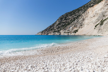 Fototapeta premium Beach with crystal clear turquoise water and white stones, waves at Myrtos beach, Kefalonia island, Greece