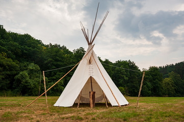 Beautiful view of the summer wedding tipi in a field. Tee pee built on green grass. Traditional teepee tent wigwam located in nature. © baisa