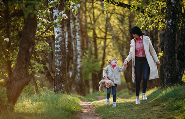 Fototapeta premium Little girl jumping with mom in the park. Are playing