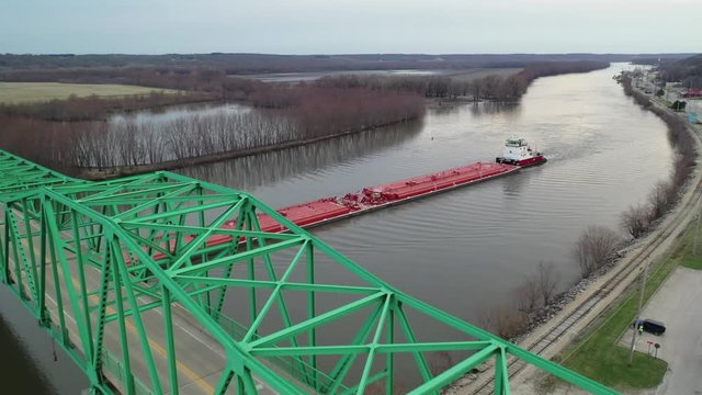 Aerial view of barge going under empty bridge