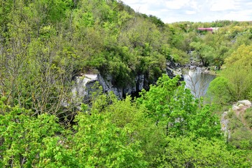 Fototapeta premium Beautiful peaceful landscape with green forest and mountain river near of the Buky canyon, Cherkasy region, Ukraine. Ukrainian landmarks. Domestic tourism. Buki canyon