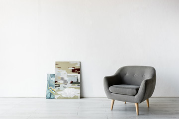 comfortable armchair near paintings in living room