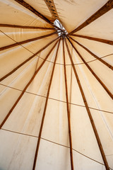 Close up of teepee tent top made of canvas and wood beams. Tee pee tent set up for camping. Interior of wigwam traditional tent.