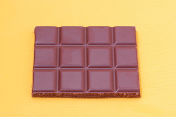 A bar of milk chocolate on a yellow background