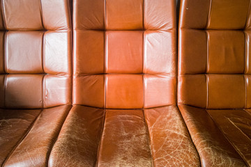 Old vintage brown leather armchairs. Cracked and worn skin from time and frequent use.