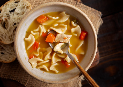 Overhead View Of Chicken Noodle Soup With Rustic Bread