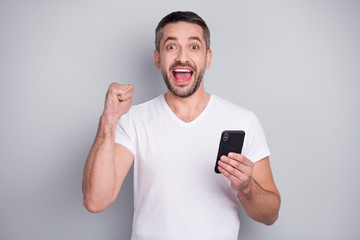 Close-up portrait of his he nice attractive glad excited cheerful cheery guy using digital device app 5g fast speed connection isolated over light grey pastel color background
