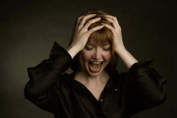 Portrait of redheaded girl. holding his hands behind his head and hysteria