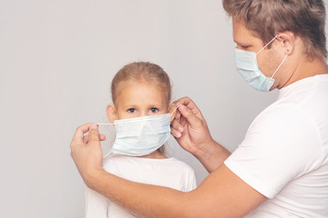 Family father and daughter in medical masks together on an isolated background