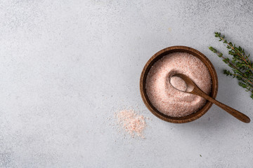 pink Himalayan salt in a bowl on a light background. Top view, place for text