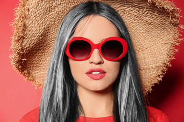 Portrait of young woman with beautiful grey colored hair on red background