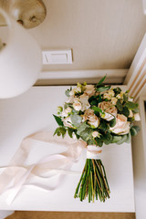 Wedding bouquet of flowers and greenery with pink ribbon