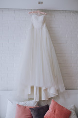 
White wedding dress hanging on the wall in the room