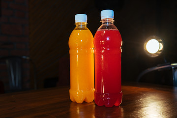 plastic bottles with soft drinks, mors and orange juice. red and yellow © kapralov