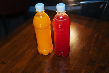 plastic bottles with soft drinks, mors and orange juice. red and yellow © kapralov