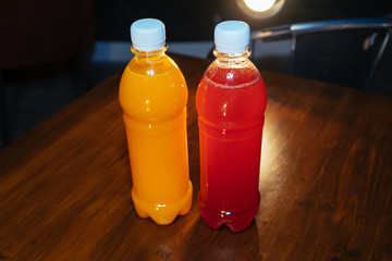 plastic bottles with soft drinks, mors and orange juice. red and yellow © kapralov