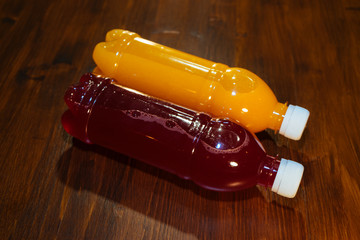 plastic bottles with soft drinks, mors and orange juice. red and yellow © kapralov