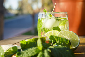 Summer time non alcoholic drink with ingredients. Caipirinha. Drink made with lime, sugar and fresh mint. Selectively focused image of homemade summer drink. 