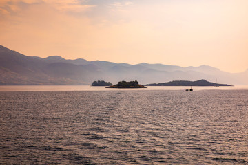 Fototapeta premium Small islands with boats in the mediterreanean adriatic sea on a sunny day calm and peaceful mindful nature and mountains in the background
