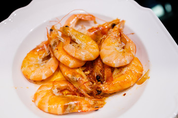 Fresh cooked shrimp in olive oil with garlic in big white plate